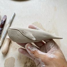 a person is making something out of clay on a table with other crafting supplies