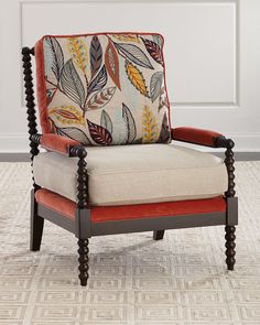 an upholstered chair sits in front of a white paneled wall and floor