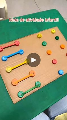 a child's play table made out of cardboard with buttons and pegs on it