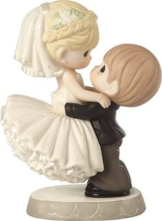 a figurine of a bride and groom kissing each other on top of a base