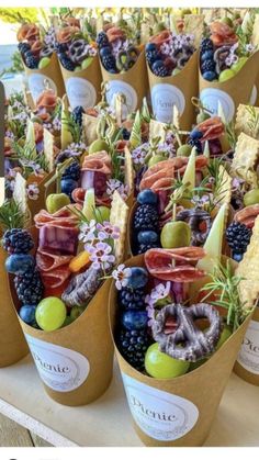 an assortment of fruits and vegetables in paper cups