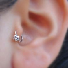 a close up of a person's ear with a nose piercing