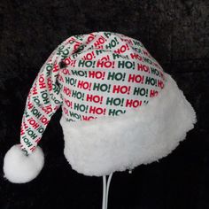 "This festive Santa hat is made up in a cheerful Christmas Ho Ho Ho fabric design in cotton flannel. The fabric is a good quality flannel fabric. The hat is accented with snowy white soft Sherpa faux fur fabric trim. Proportions of the hat are generous and will fit most head sizes, ladies or gents. The styling is a slouch cone, traditional Santa look. Measurement for opening for your head is 26\" circumference and the length is 18\". There is a snowy white pompom on the top. If you need more tha White Christmas Hat, Adjustable Christmas Costume Hats, Chrustmas Fabric Hat, White Christmas Holiday Hat, Christmas Host Gift, White Adjustable Fur Felt Hat, Christmas Party Hats, Santa Claus Hat, Hosting Christmas