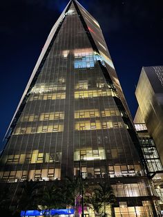 a very tall building lit up at night with lights on it's sides and windows