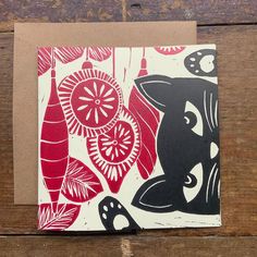 a red and black greeting card on a wooden surface