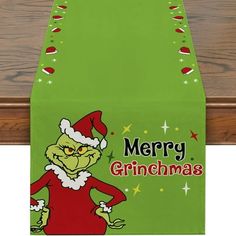 a green christmas table runner with an image of the grin on it