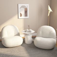 two white chairs sitting next to each other on top of a carpeted floor in a living room