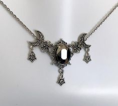 This is a new handmade necklace. It is made with antiqued silver plated filigrees, accented with a high quality HEMATITE glass rhinestone. Decorated portion is 2 1/2" wide and 1 3/4" tall in the center. Necklace is adjustable 15-18" with a lobster clasp and chain extender. If you would like a different length, please send us a message. Gothic Engraved Antique Silver Necklace, Gothic Pewter Jewelry In Silver, Gothic Silver Pewter Jewelry, Gothic Silver Crescent Necklace, Gothic Crescent Silver Necklace, Adjustable Gothic Antique Silver Necklace, Witchy Wedding, Victorian Choker Necklace, Star Goddess