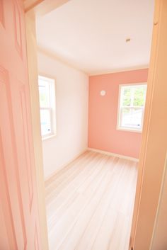 an empty room with pink walls and white floors is seen in this image from the doorway