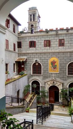 an arched doorway leads to a courtyard with stairs