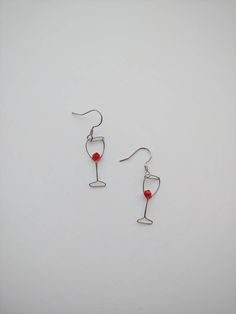 "These cute little matching wine glasses have 4mm bicone glass beads wrapped inside. Made with 100% stainless steel 24 and 30 gauge wire and earring hooks. They hang approximately 1\" down from earring hook. Earrings will come on an earring card with plastic earring backs. All my jewelry is handmade, and made with patience, care and love. In the unlikely event that it needs to be repaired, I'll do it free of charge." Wine Glass Earrings, Party Glass Jewelry Wire Wrapped, Party Wire Wrapped Glass Jewelry, Minimalist Wire Wrapped Beaded Earrings For Gift, Wine Earrings, Glass Beaded Dangle Earrings For Gift, Glass Beaded Dangle Earrings For Parties, Red Wire Wrapped Earrings For Party, Nickel-free Beaded Glass Earrings As Gift