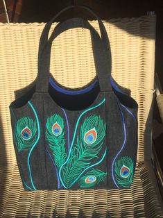 a black purse with peacock feathers on it