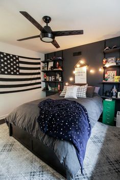 a bedroom with an american flag on the wall and a bed in front of it