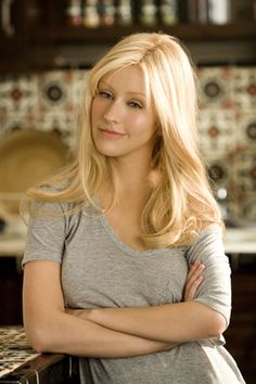 a woman standing in a kitchen with her arms crossed