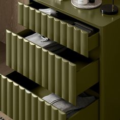 an image of a green dresser with drawers and items on it's sideboard