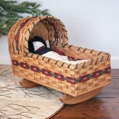 a baby's bed made out of wicker with a tree in the background