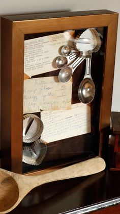 spoons and other kitchen utensils are in a shadow box with writing on it