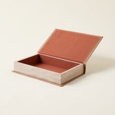 an empty wooden box sitting on top of a white surface