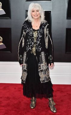 an older woman with white hair and black dress on the red carpet at an awards event