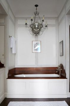 a bathroom with a chandelier hanging from the ceiling and a bathtub in the corner