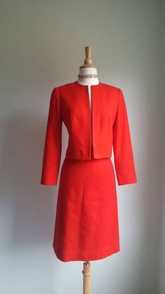 An intense, saturated red brightens any occasion, from the office to after hours. Clean, tailored lines and a slim fit add a '60s mod appeal. Set includes pencil skirt and open jacket with no closures. Fine wool exterior; fully lined in nylon satin. Era: 1990s Label: Pendleton JACKET (somewhat open fit, no closures) Bust: up to 34-36 inches Length from shoulder to hem: 19 inches SKIRT Waist up to 26 inches Hips/seat: up to 37 inches Length: 24.5 inches Tailored Red Skirt Suit For Office, Classic Red Skirt Suit For Work, Red Fitted Blazer For Career, Pendleton Jacket, Open Jacket, Pendleton Wool, 60s Mod, Dress Suit, Wool Dress