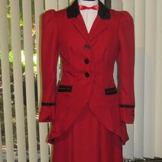 a red suit with black trims and buttons on the lapel is sitting on a mannequin