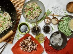 a table topped with plates and bowls filled with different types of food next to utensils