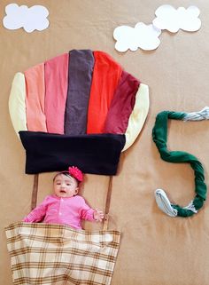 a baby laying in a chair made out of paper