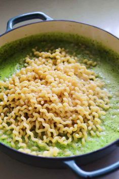 a pan filled with noodles and broccoli on top of a stove