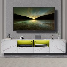 a large television mounted to the side of a wall next to a white cabinet in a living room