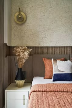 a bed with orange and blue pillows on top of it