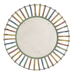 a circular mirror with multicolored sticks in the center on a white background,