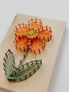 two orange and green pinwheels sitting on top of a piece of wood next to each other