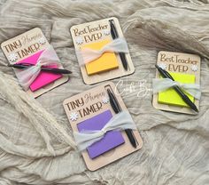 four sticky notes with writing on them are laying on a sheet of fabric and tied together