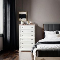 a white bed sitting next to a window in a bedroom on top of a hard wood floor