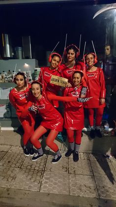 a group of women in red outfits posing for a photo