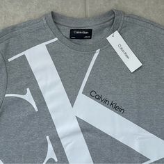 Calvin Klein Men's Ck Sweatshirt Heroic Grey Heather Size: Xl Brand New Calvin Klein Big Ck Logo On Front For An Iconic Design Super Soft, Loungewear Comfort Crewneck And Long Sleeves Ribbed Knit Cuffs, Waistline, And Collar Product Details: With An Iconic Logo Styling Front, This Calvin Klein Sweatshirt Features A Plush Cotton Knit Blend For Premium Comfort. Finished With A Crewneck, Long Sleeves And Ribbed Knit Trim For A Snug Fit. A Fashion Essential, This Calvin Klein Pullover Is A Versatile Calvin Klein Cotton Crew Neck Top, Calvin Klein Crew Neck Top With Logo Print, Calvin Klein Logo Print Crew Neck Top, Calvin Klein Relaxed Fit Logo Print Top, Calvin Klein Cotton Tops With Logo Print, Sporty Calvin Klein Tops With Logo Print, Calvin Klein Casual Tops For Streetwear, Casual Calvin Klein Tops For Streetwear, Calvin Klein Relaxed Fit Letter Print Top