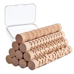 several pieces of wood are stacked up in front of an open tin box on a white background