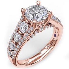 a rose gold engagement ring with three stones on the band and an oval center stone surrounded by smaller round diamonds