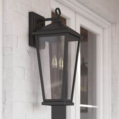 two lights are attached to the side of a white brick wall mounted light fixture on an exterior door