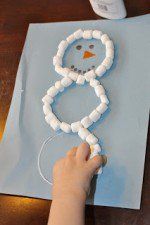 a person making a snowman made out of toilet paper on top of a table