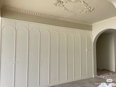 an empty room with several white closets and a chandelier hanging from the ceiling