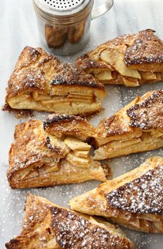 several pieces of french toast sitting on top of a table next to a jar of powdered sugar