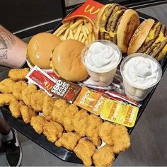 a tray filled with chicken nuggies, fries and burgers next to ketchup