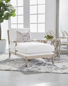 a living room with white furniture and plants