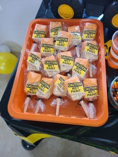 an orange tray filled with marshmallows and candies on top of a table