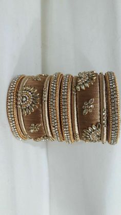 a bunch of bracelets that are stacked on top of each other in gold and silver