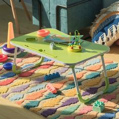 a child's play table with toys on it in the middle of a room