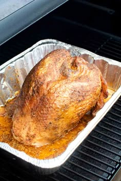 a roasted turkey in foil on the grill with text overlay that reads, smoked turkey breast