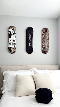 two skateboards mounted to the wall above a bed with pillows and blankets on it